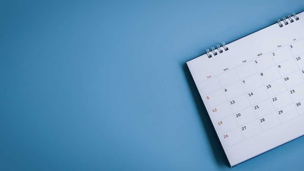 Calendario abierto en un mes, mostrando los días de la semana desde domingo a sábado, con las fechas en formato de cuadrícula en números negros y los domingos resaltados en rojo.